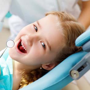 Una bambina sorridente sulla poltrona del dentista