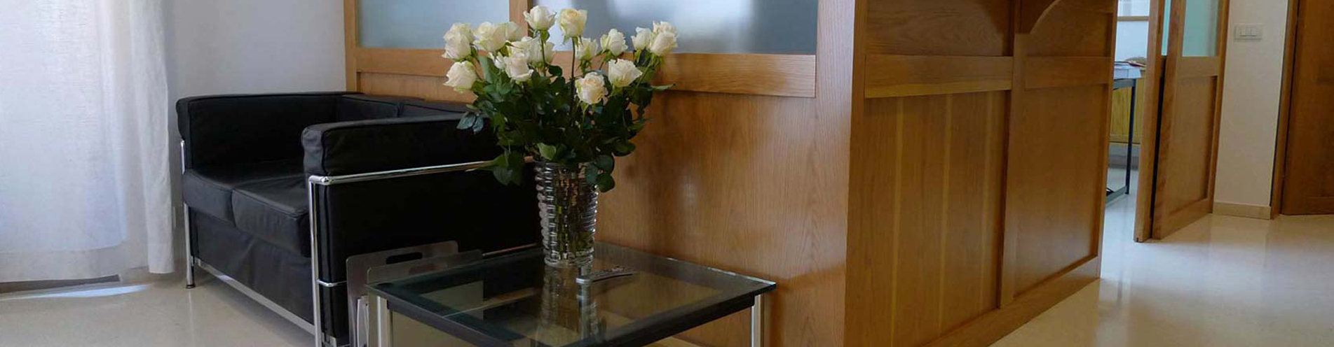 La sala d'attesa con divano e rose bianche accanto alla reception