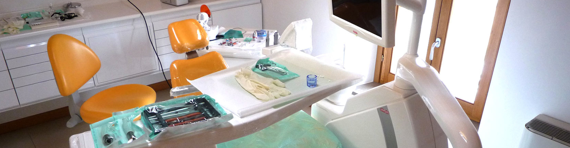 Studio odontoiatrico con riunito e strumenti sterilizzati in buste sigillate